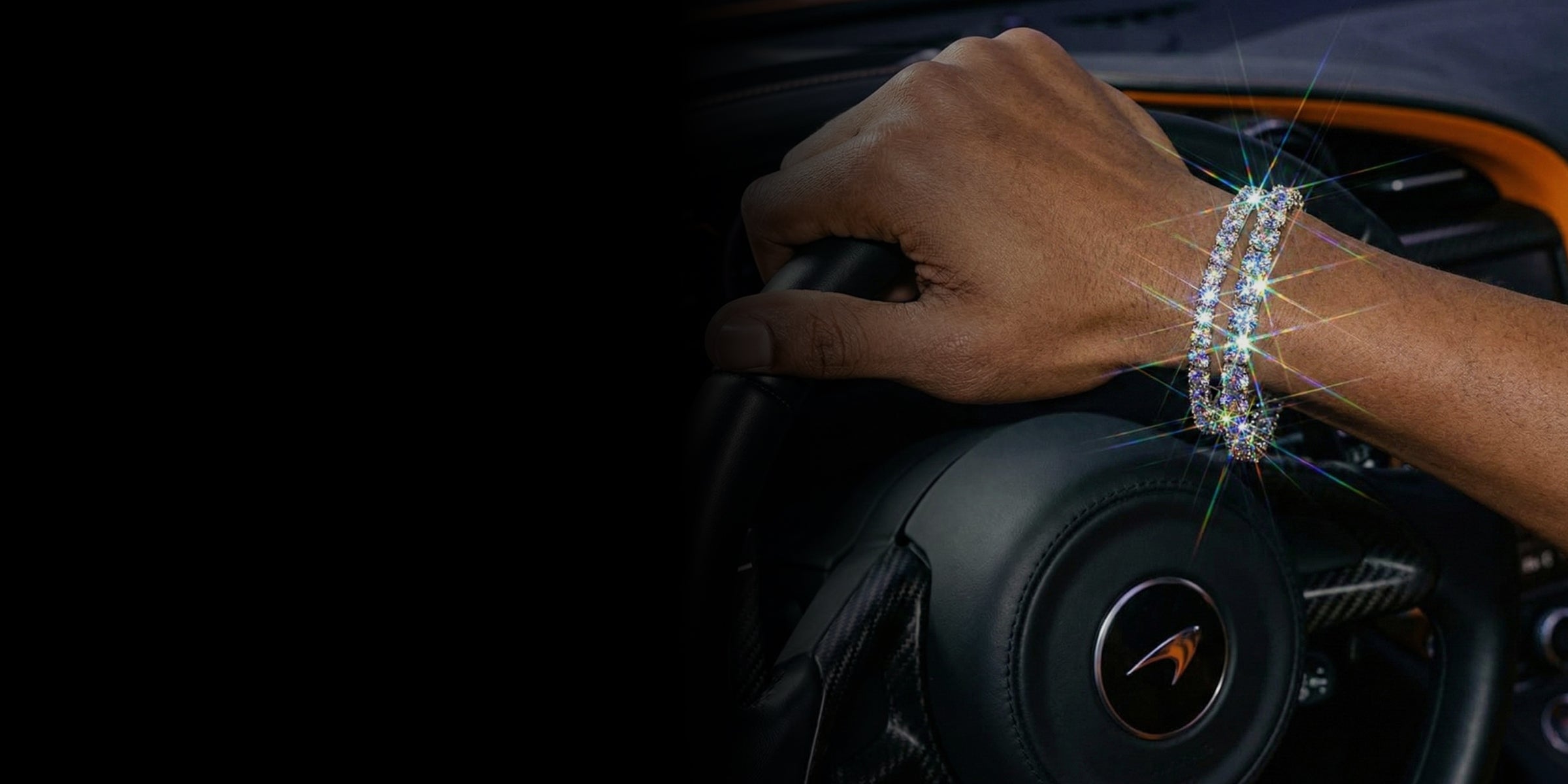 Hand with a bracelet on a car steering wheel, with a blurred background
